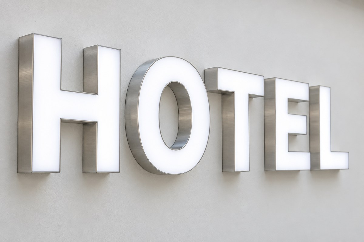 حروف چلنیوم HOTEL با رویه سفید روشن و لبه فلزی روی دیوار